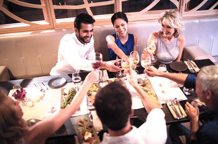 People toasting wine glasses at dinner