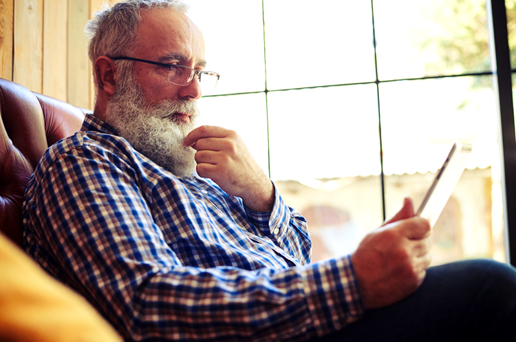 Man on couch looking at tablet