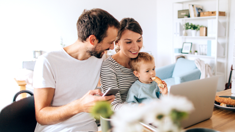 Man and woman with infant looking at computer