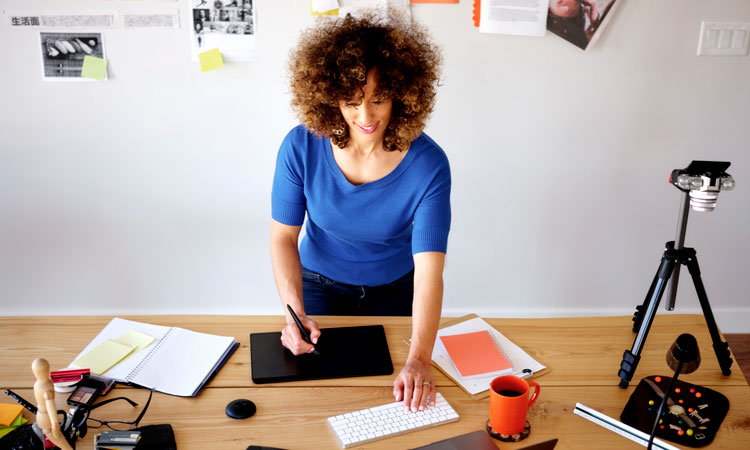 Woman stands at desk